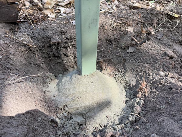 Steel galvanised post sprayed with corrosion inhibiting paint and new concrete applied in a dome manner to finish above ground level