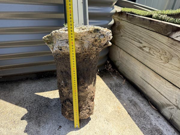 Excavated concrete pier of a Colorbond fence post