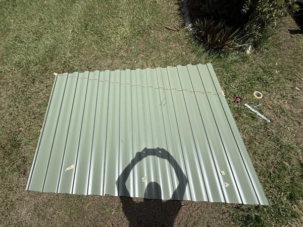 Colorbond infill panels Wavlock in mist green having a cut line drawn onto them using string to measured points.